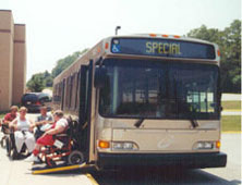 A port authority bus from the 1970s with its wheelchair ramp extended, loading some passengers