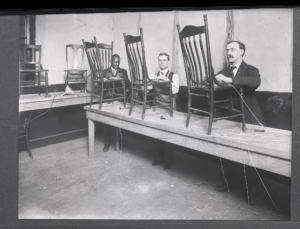 Historic photo shows three blind men weaving chair seats.