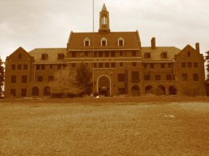 A faded photo of the Western Center, a wide brick building with a tall steeple in the middle top