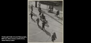 Children playing on a basketball court at Bedford School in nineteen fifty seven.