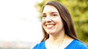 Head shot of Jessica Benham. She has long brown hair and a big smile.