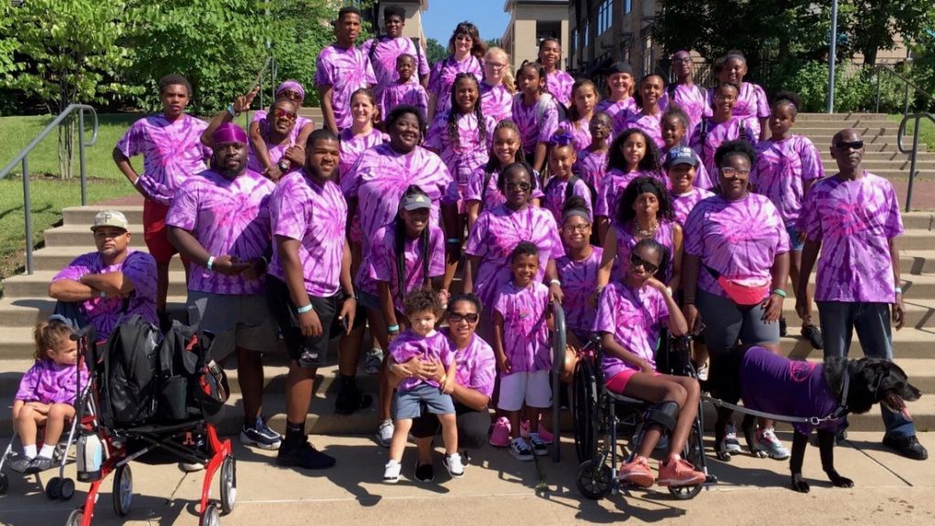 A group of people wearing purple shirts at a Rika's Hearts funderaiser.