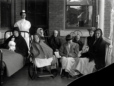 A group of women in an old black and white photo, including a nurse and residents of an institution for people with disabilities