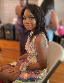 Maurika Moore, seated at a table and smiling