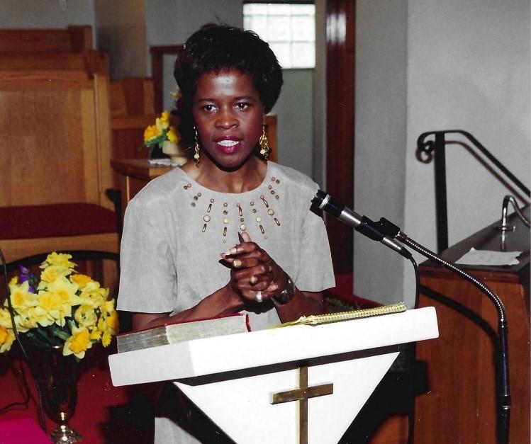 Marilyn speaking at the podium in front of her church congregation