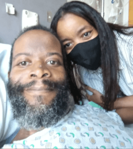 David in a hospital bed with his sister beside him, both are smiling