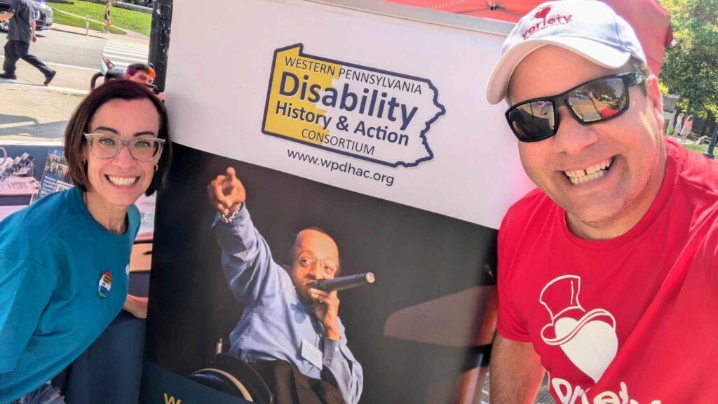 Two people visiting our table at Disability Pride