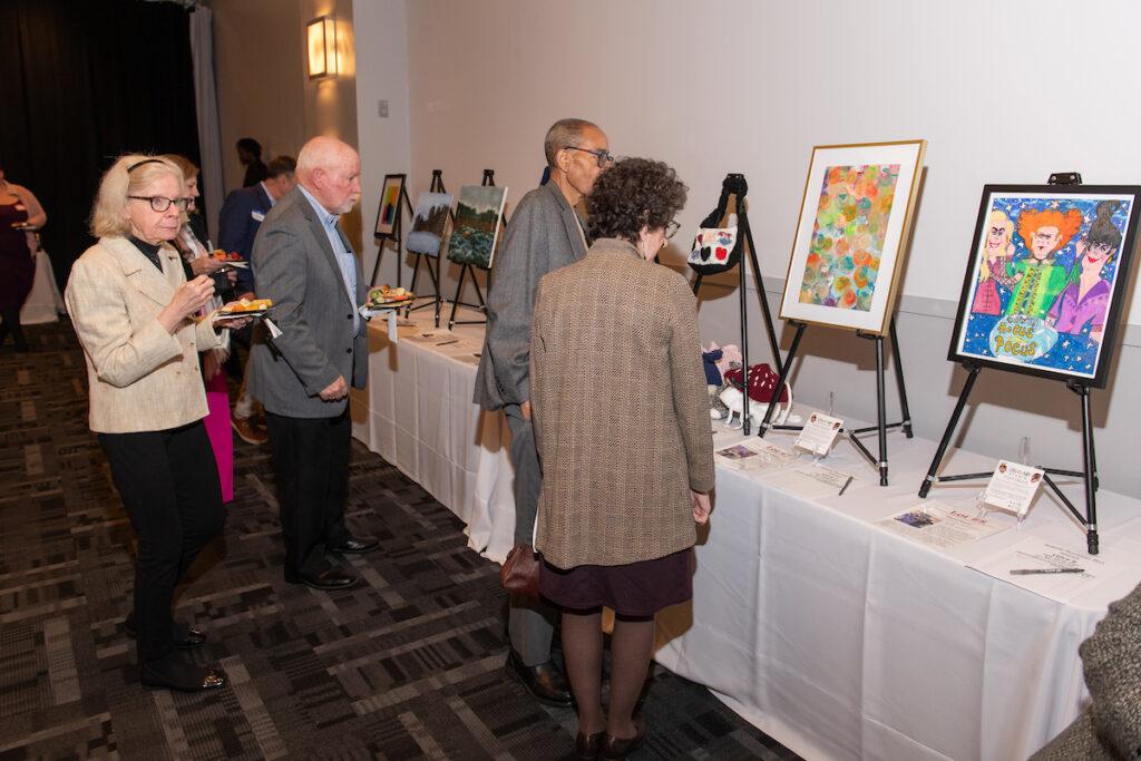 More attendees bidding at the art auction.