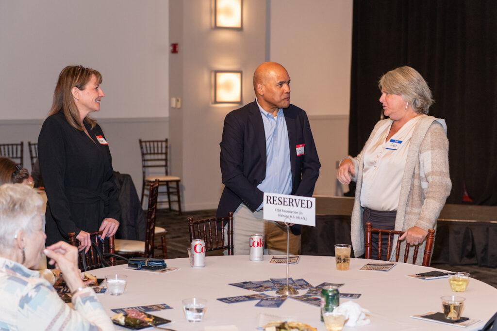 A man and two women networking during the reception.