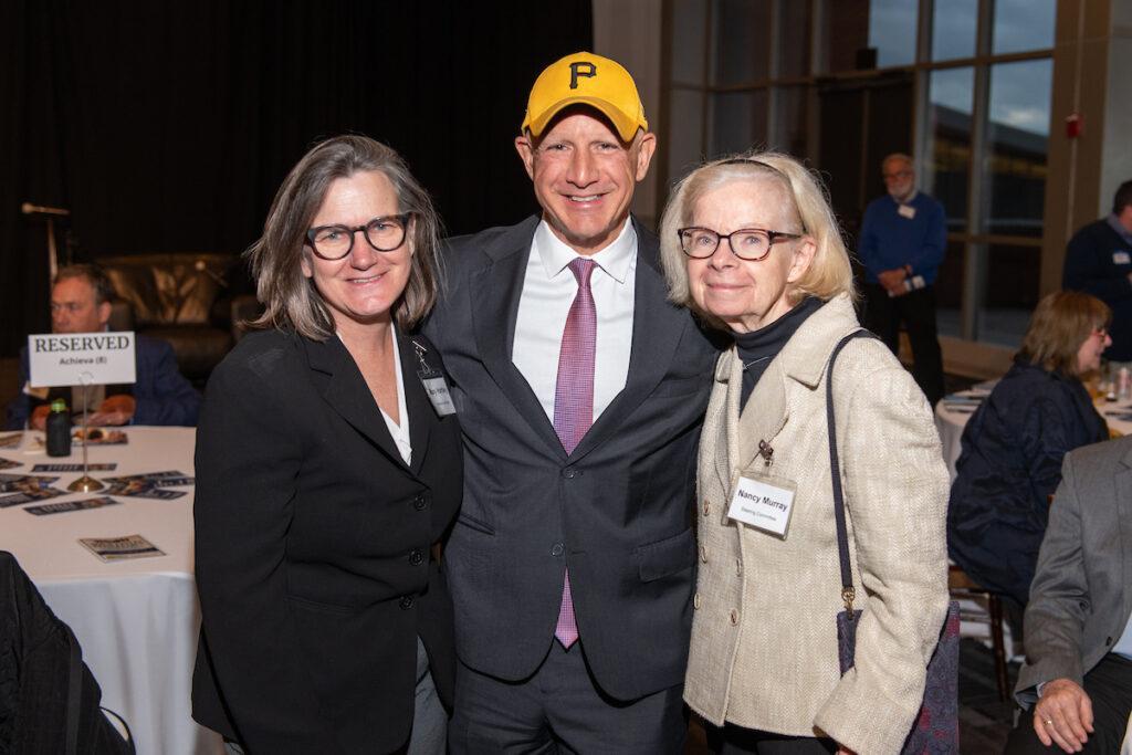 Two woman and a man pose for a photo.