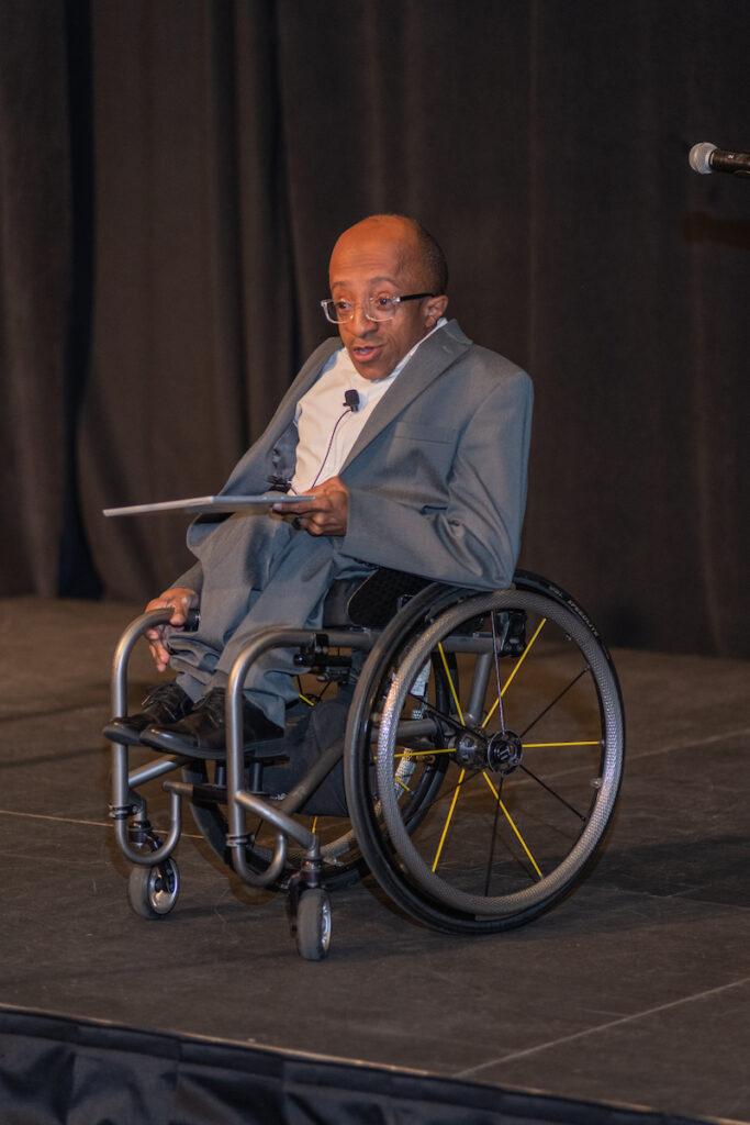 Chaz Kellem introducing the program from the stage.