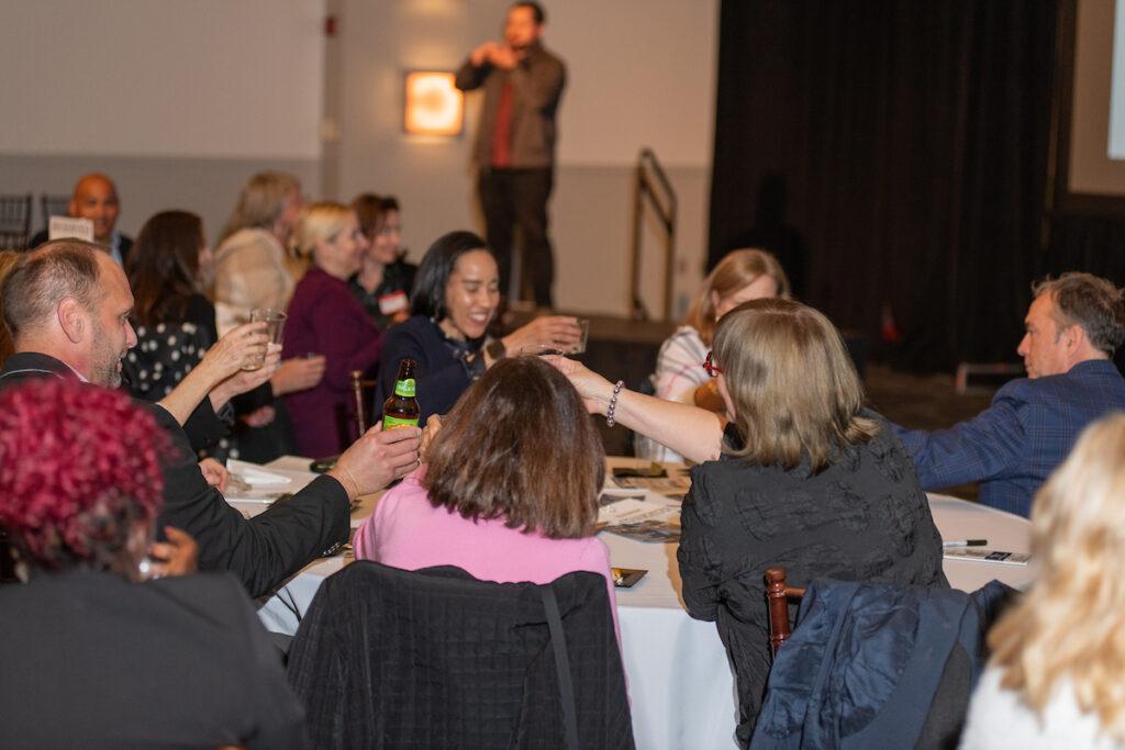 Guests seated at tables, raising their glasses for the toast.
