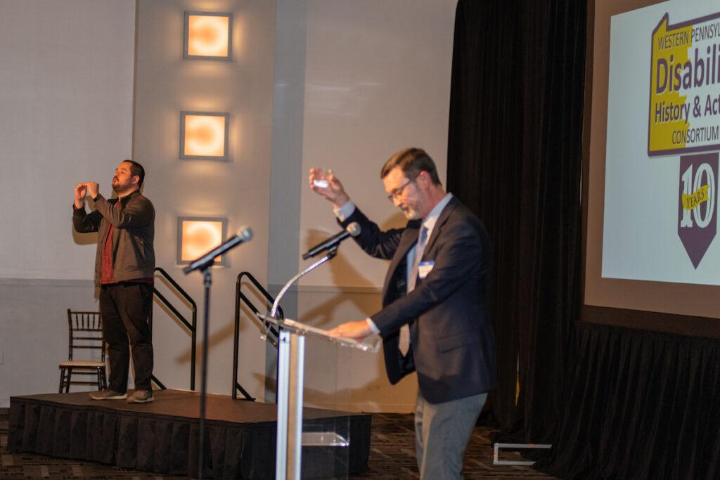 Steve Suroviec at the podium, raising a glass as he gives the toast to the Consortium.