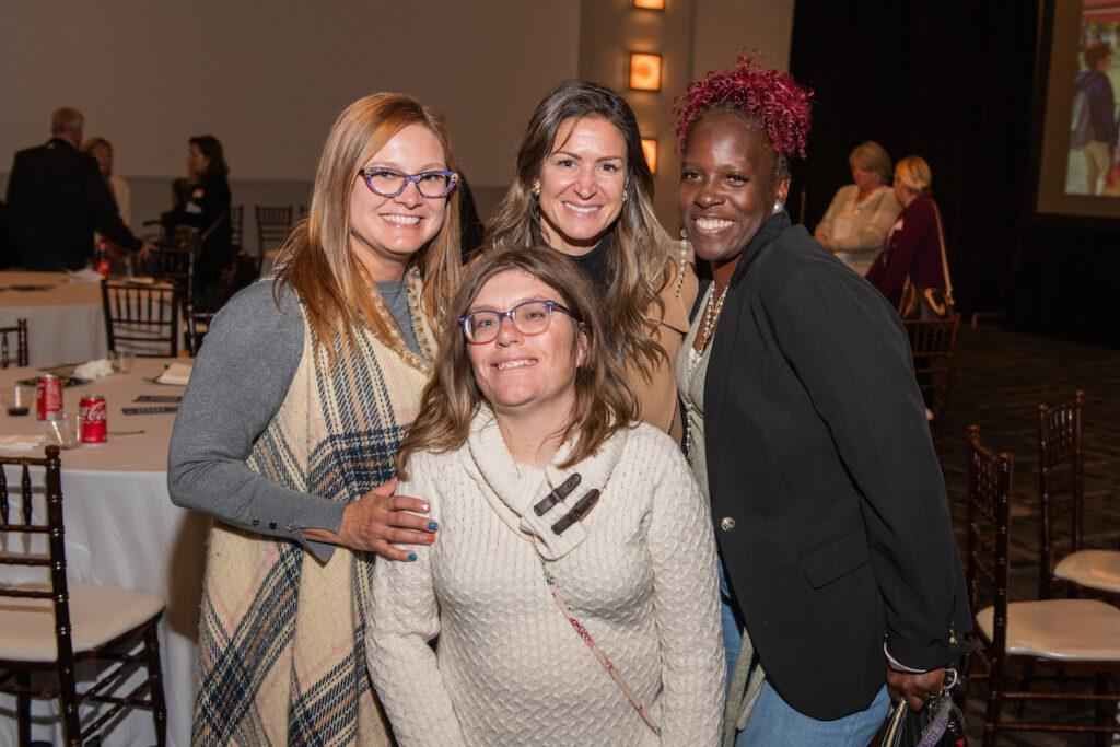 A group of sponsors pose for a photo - four women.