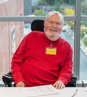 John L. Tague, Jr. smiling while volunteering at the registration desk during the Consortium’s Beyond History 2025 event.